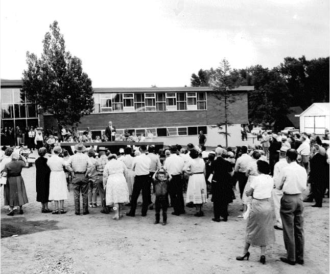 Crowd gathered outside midcentury school building